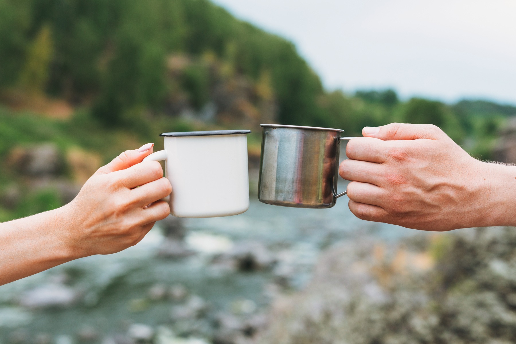 Couple Toasting Tin Mugs in a Camp 